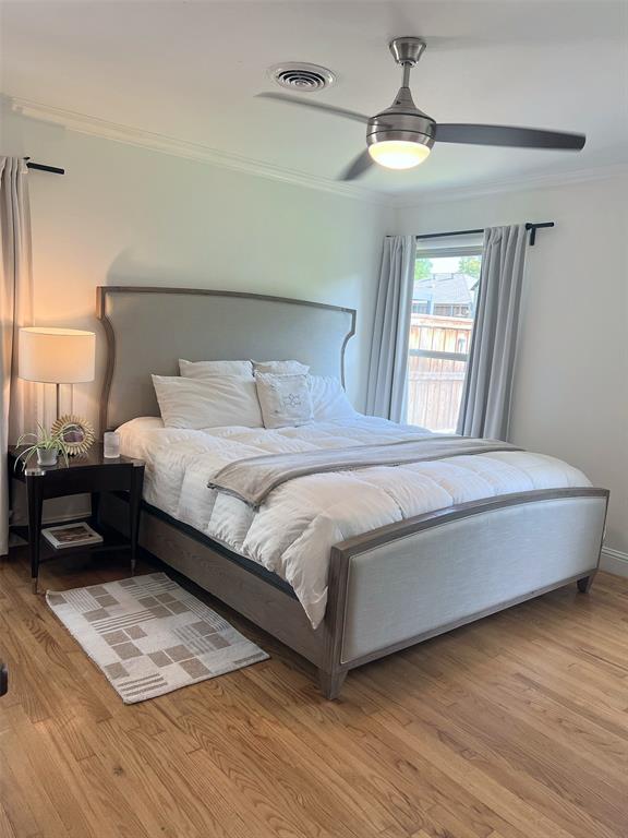 Hardwood flooring, crown molding, and a ceiling fan with integrated lighting