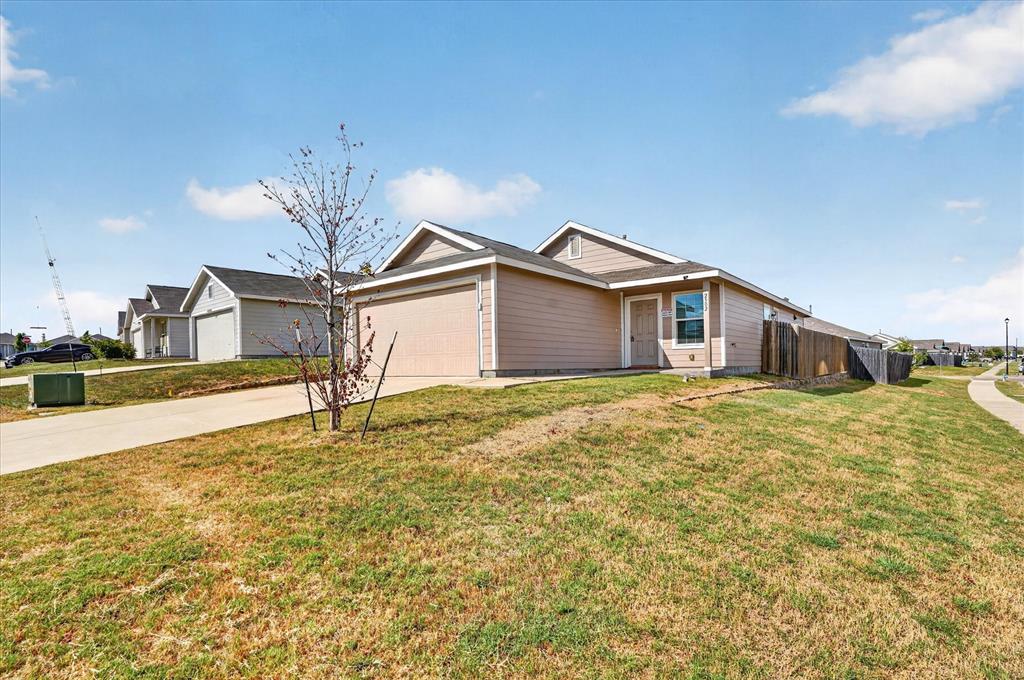 Single-story residence featuring a two-car garage, fenced backyard, and a paved driveway