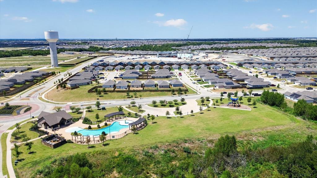 Community pool with integrated splash pad, adjacent clubhouse, and landscaped green space