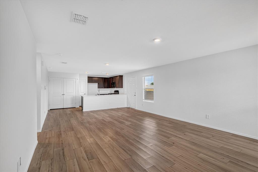 Open-concept living space featuring wood-finish flooring, recessed lighting, and a white kitchen island