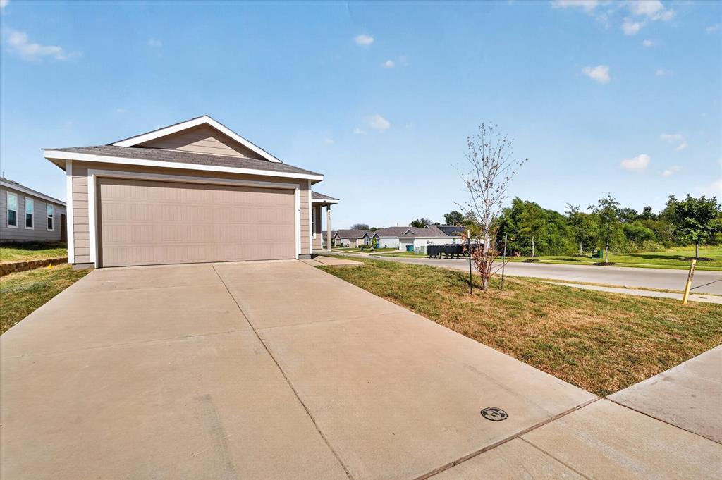 Attached two-car garage with a concrete driveway, siding exterior, and a gabled roofline