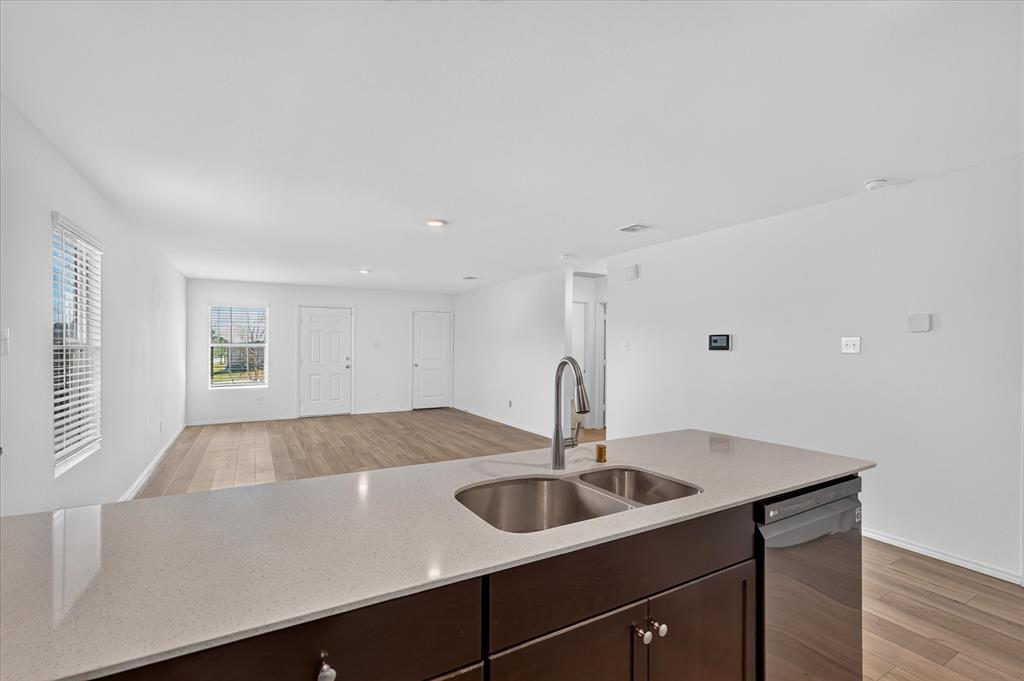 Kitchen island with a double stainless steel sink, gooseneck faucet, and light-toned countertop