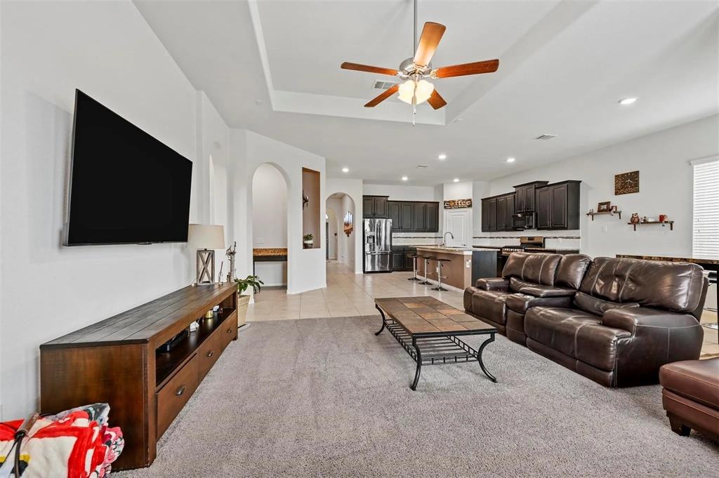 Tray ceiling with a ceiling fan, recessed lighting, arched doorways, and tile flooring Tray ceiling with a ceiling fan, recessed lighting, arched doorways, and tile flooring