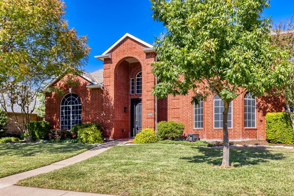 Red brick exterior featuring a prominent arched entryway, gabled roofline, arched window detailing, and manicured landscaping Red brick exterior featuring a prominent arched entryway, gabled roofline, arched window detailing, and manicured landscaping