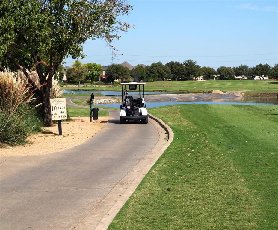 Golf course grounds featuring paved cart paths, water hazards, mature trees, and manicured landscaping