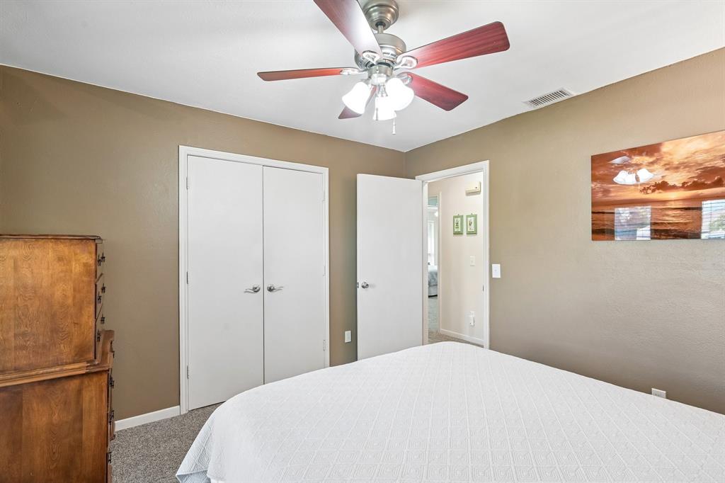 Ceiling fan with light fixture, neutral wall finishes, and gray carpet flooring