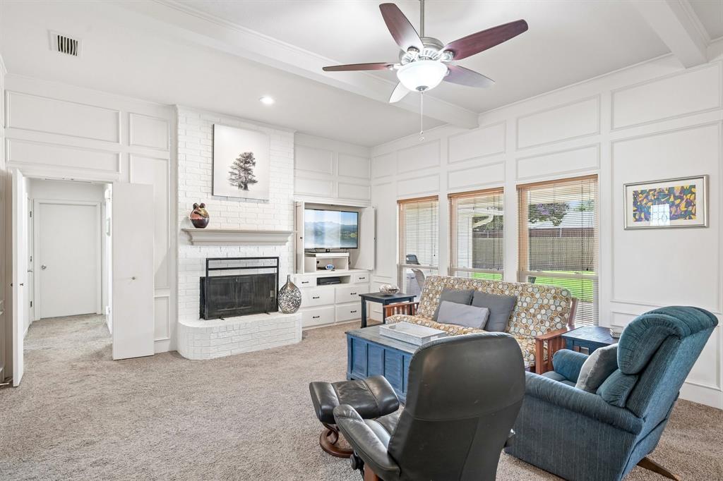 Living area featuring white brick fireplace, built-in entertainment console, coffered ceiling, and multiple windows