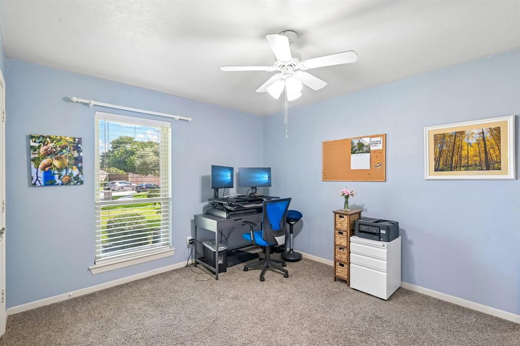 Recessed window with blinds, ceiling fan with light fixture, and carpet flooring