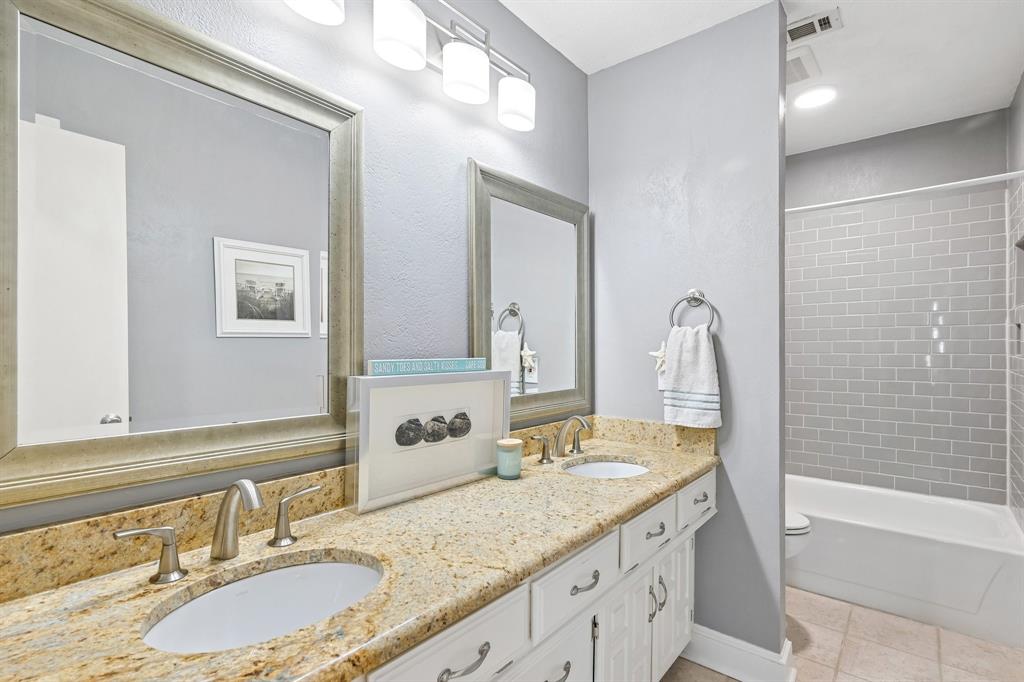 Dual vanity with stone-finish countertop, undermount sinks, and brushed nickel fixtures