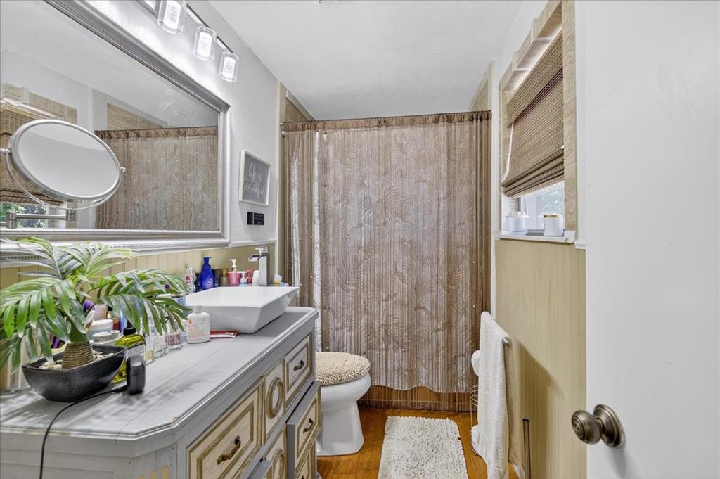 Primary bathroom with framed mirror, updated lighting and vanity.