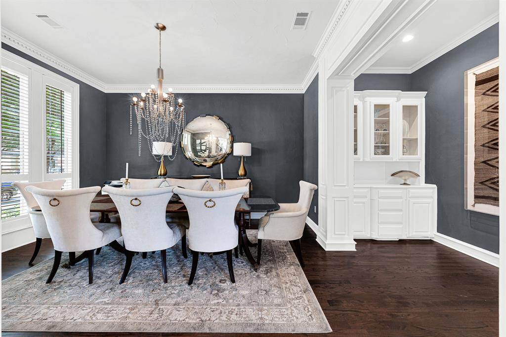 Dramatic charcoal walls and a glittering crystal chandelier elevate this formal dining space, complete with a built-in white buffet and server station. Host memorable holiday dinners and celebratory family meals in a space designed for effortless hospitality.