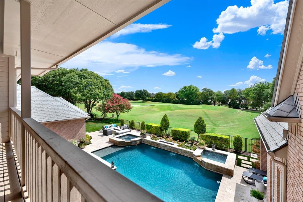 Welcome to 5325 Blake Drive. Elevated views from the upper balcony capture the sparkling custom pool, dual spa features, and extensive sun deck. Lush rolling fairways and mature trees of the adjacent golf course provide an expansive green backdrop directly beyond the property line.
