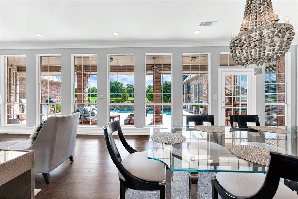 A wall of floor-to-ceiling windows frames uninterrupted views of the resort-style pool patio and green fairway beyond. This casual dining nook bathes morning meals in natural light while offering quick access through French doors to the outdoor covered patio, pool and coveted golf course views.