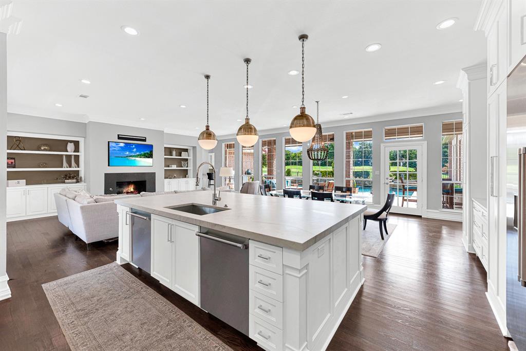 Positioned at the heart of the home, the island overlooks both the fireplace-anchored family room and walls of windows viewing the pool and golf course. It offers maximum prep surface, hidden cabinet storage, and dishwashers to keep host cleanup effortless while staying connected with guests.
