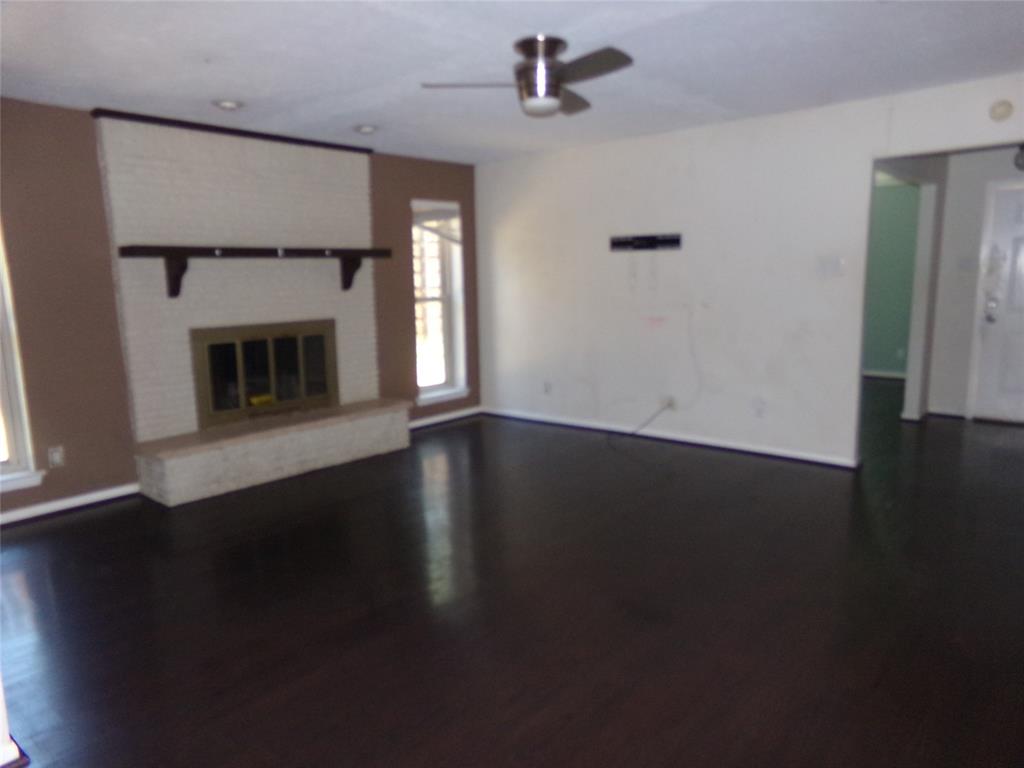 Dark wood-finish flooring, white brick fireplace with hearth, recessed lighting, and ceiling fan Dark wood-finish flooring, white brick fireplace with hearth, recessed lighting, and ceiling fan