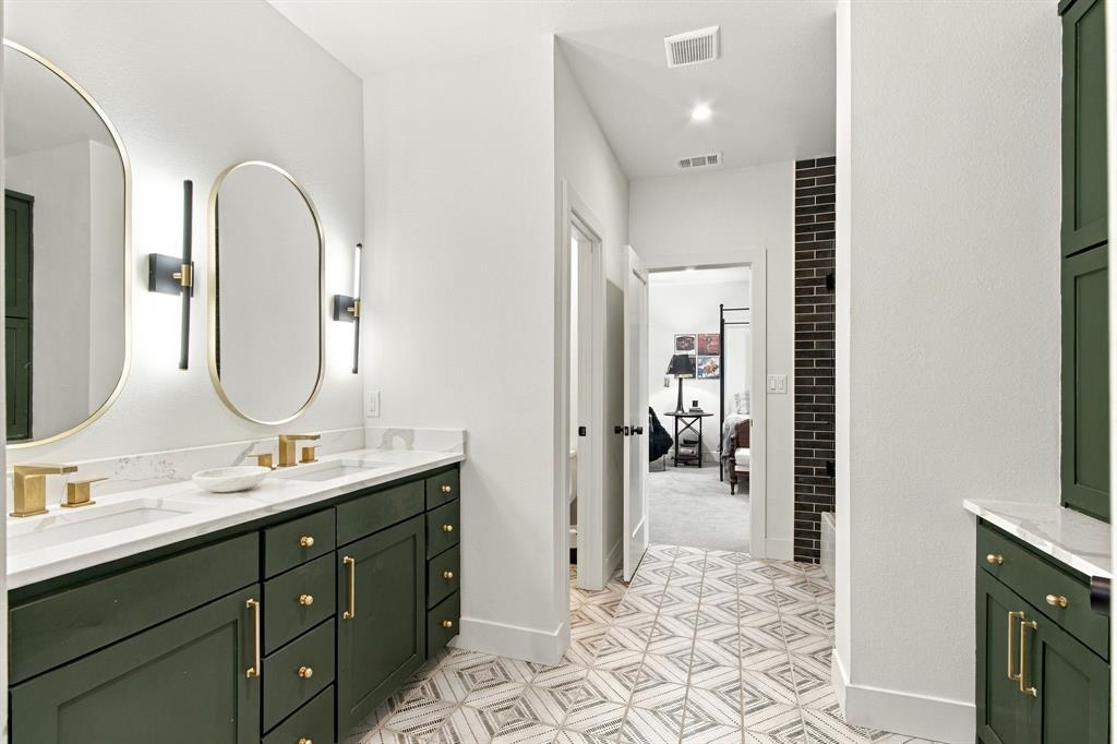 Dual vanity with green cabinetry and gold-tone hardware
