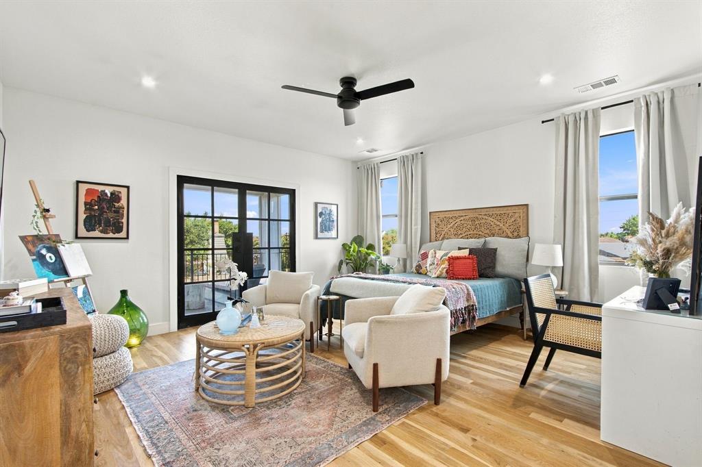 Wood-finish flooring, recessed lighting, and a black ceiling fan illuminate this bright space