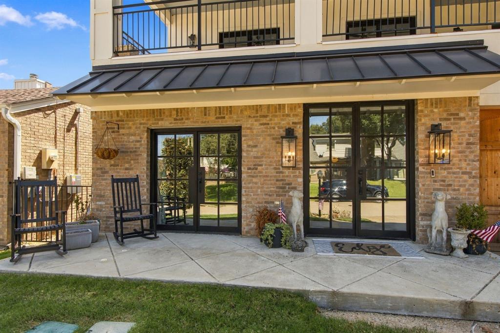 Brick exterior with black-framed double doors, a metal awning, and integrated outdoor lighting