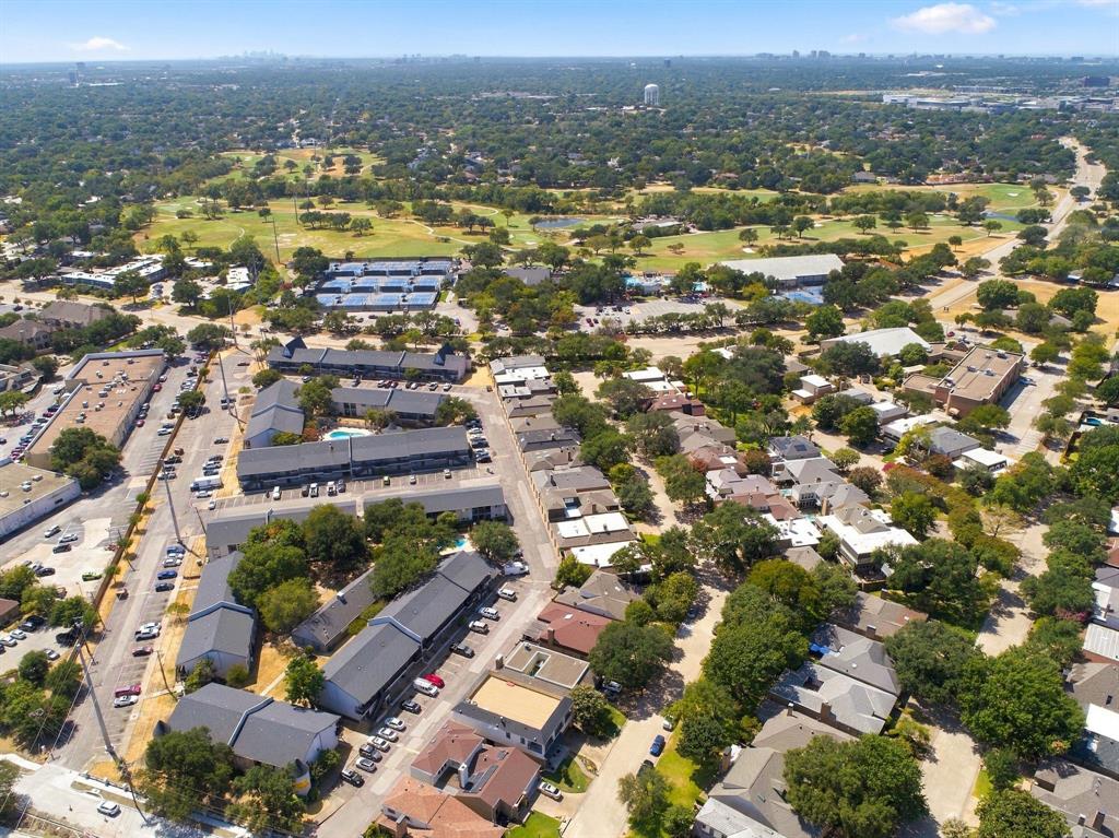 Aerial perspective featuring a residential area with varied rooflines and extensive tree canopy