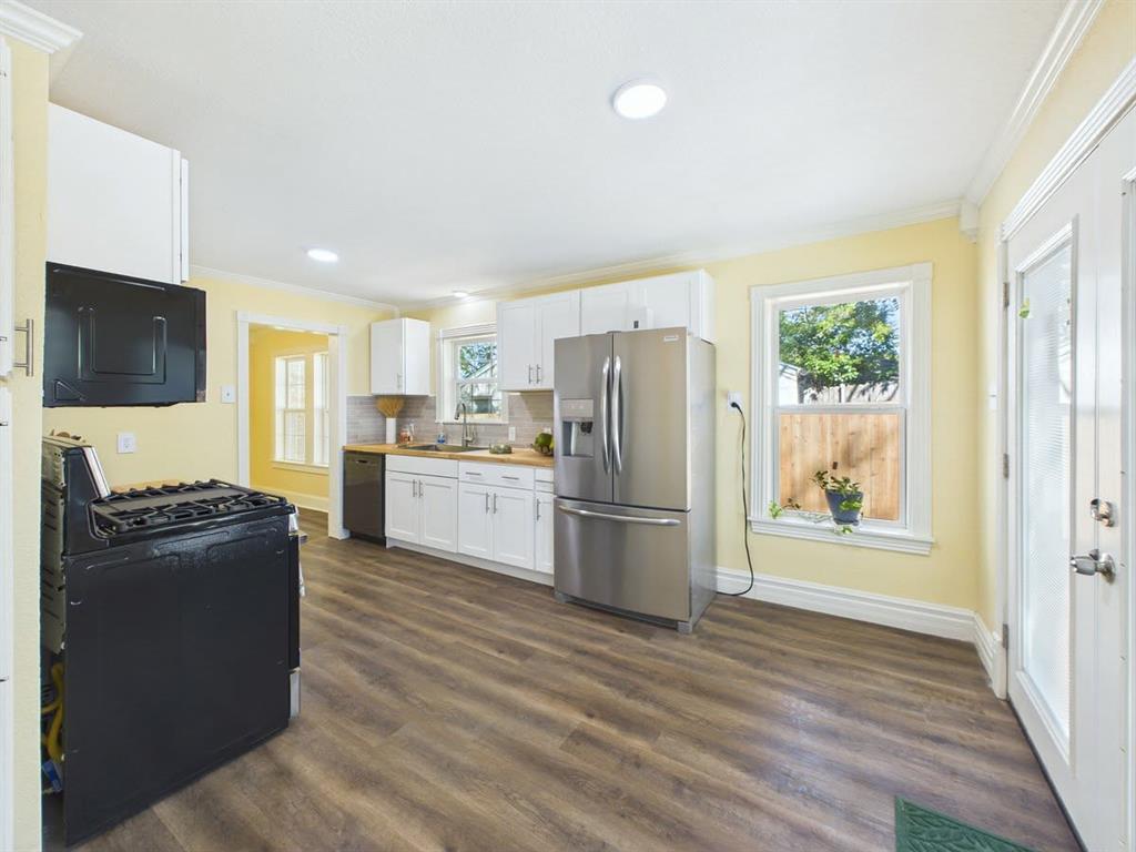 Kitchen featuring wood-finish flooring, white cabinetry, recessed lighting, stainless steel refrigerator, and a built-in dishwasher