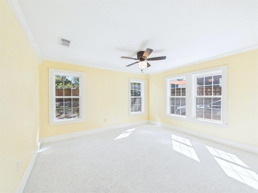 Room with multiple double-hung windows, crown molding, and a ceiling fan with integrated lighting