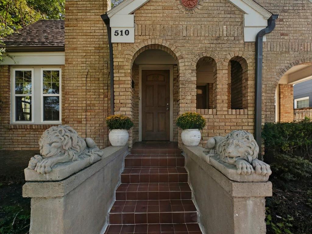Brick facade with arched entry, complementing brick archways, tiled steps, and decorative stone balustrades