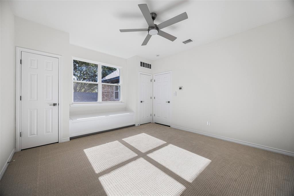 Spacious secondary bedroom features lots of storage with multiple closets, and a built-in window seat beneath a large window that brings abundant daylight into the room.