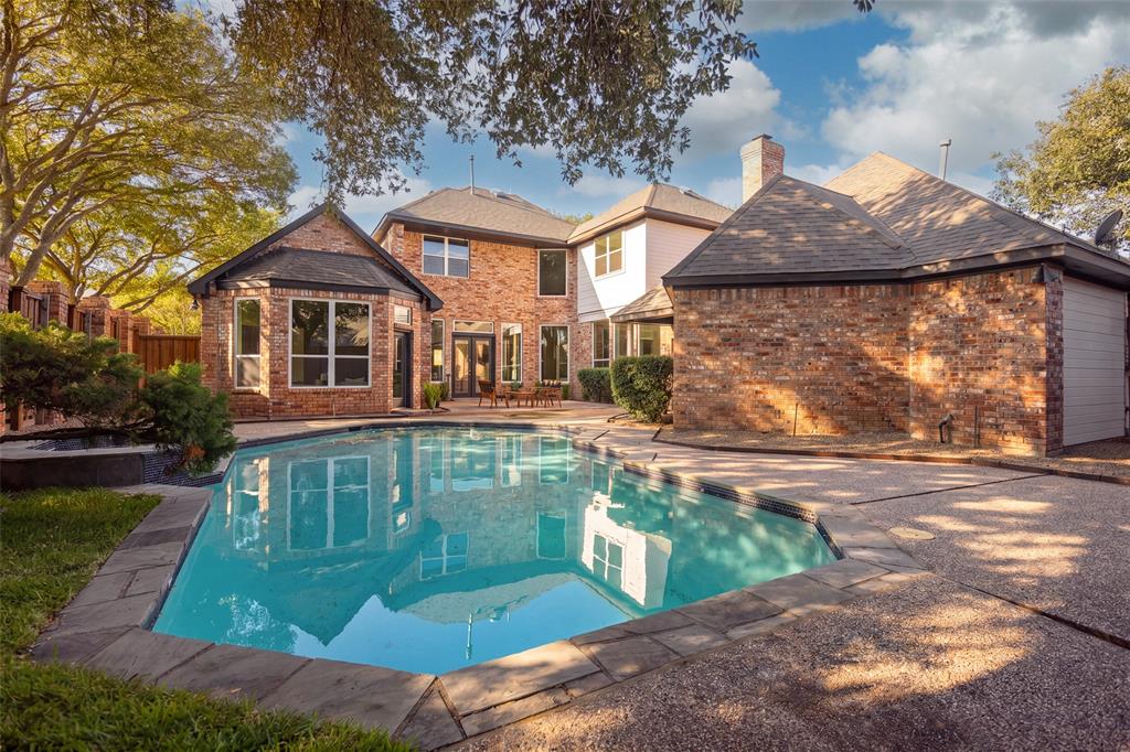 Private backyard centered around an in-ground pool and spa, with generous surrounding deck space, mature landscaping, and the home's expansive rear elevation creating an inviting setting for outdoor entertaining
