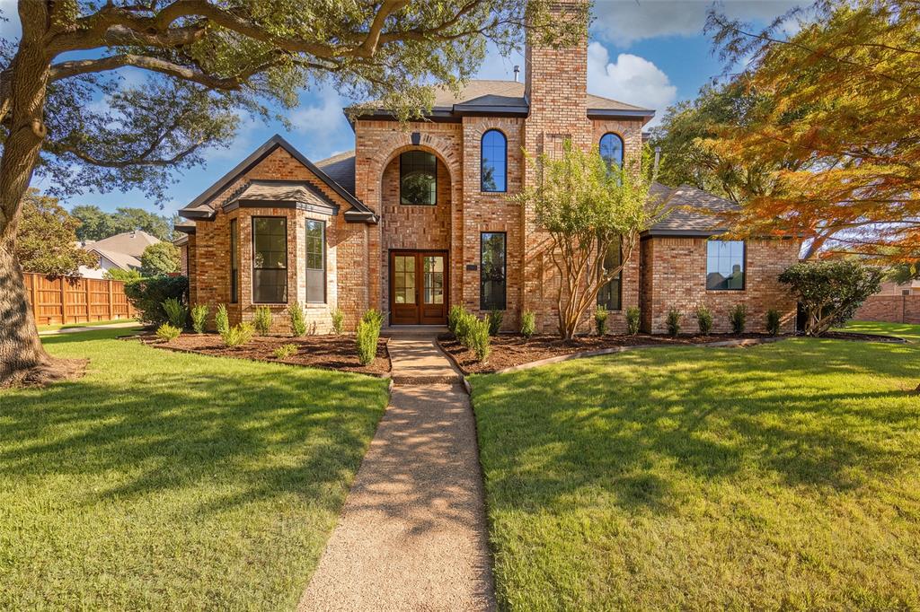 Impressive two-story brick exterior framed by mature trees and fresh landscaping, with a dramatic arched entry, updated double wood-and-glass entry doors, and distinctive architectural windows. Impressive two-story brick exterior framed by mature trees and fresh landscaping, with a dramatic arched entry, updated double wood-and-glass entry doors, and distinctive architectural windows.