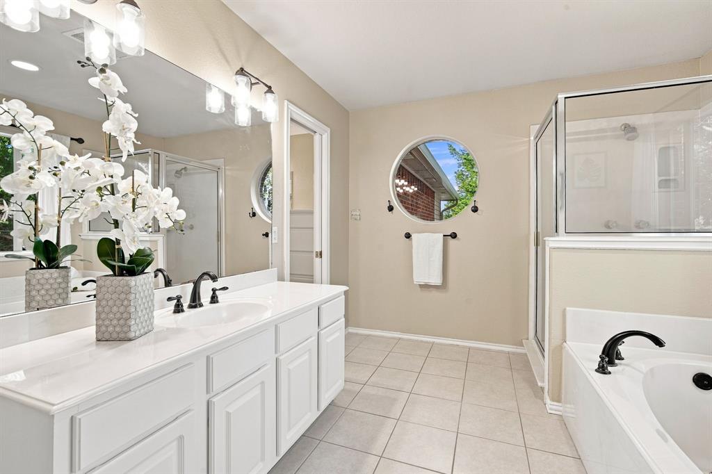 Spacious double vanity bathroom with crisp white cabinetry, polished countertops, and dual undermount sinks.