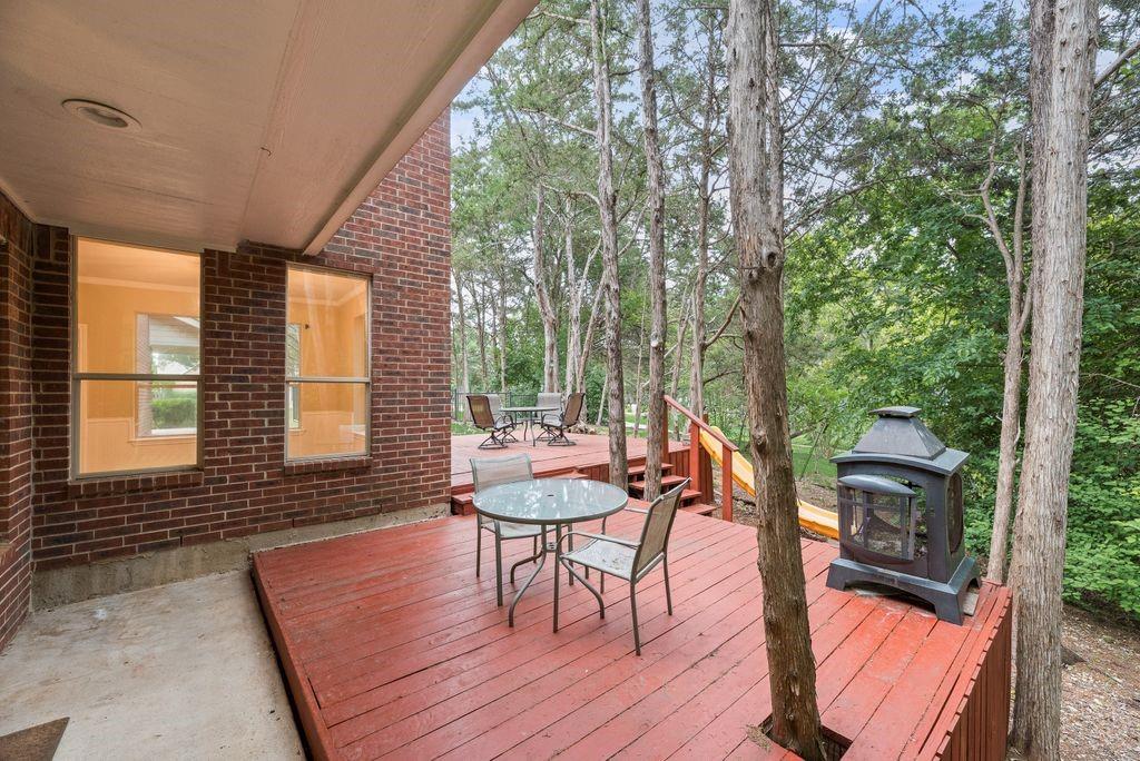 Multi-level wood deck with integrated trees and a brick exterior
