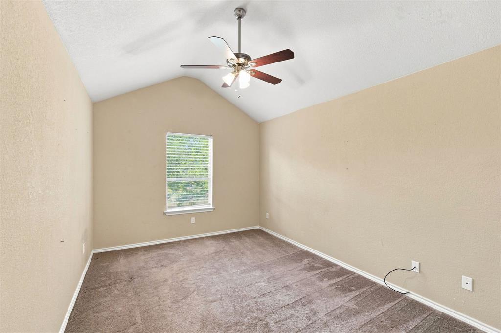 Bright room with a vaulted ceiling, ceiling fan, and calming neutral tones, ready for your personal touch.