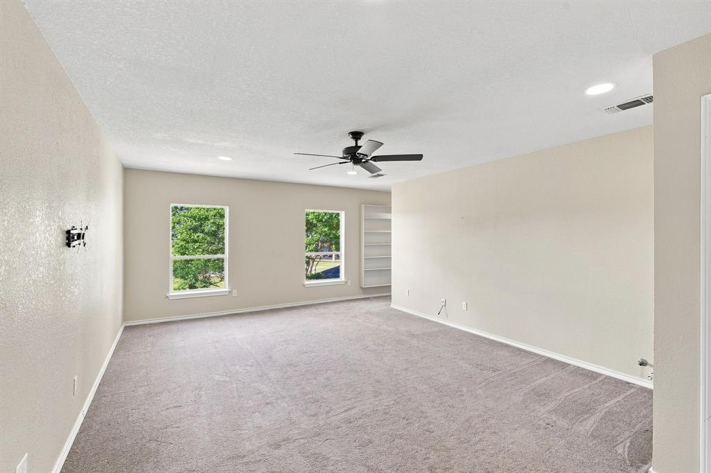 Cozy, light-filled room with recessed lighting, a ceiling fan, two windows, and built-in shelving, flexible space for any lifestyle.