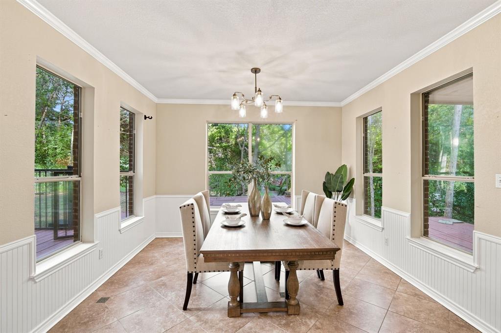 Elegant dining area featuring classic beadboard wainscoting, crown molding, and plenty of natural light from multiple windows.