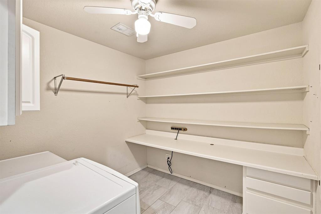 Functional laundry and utility space with recessed lighting, built-in cabinetry, and a hand folding station.