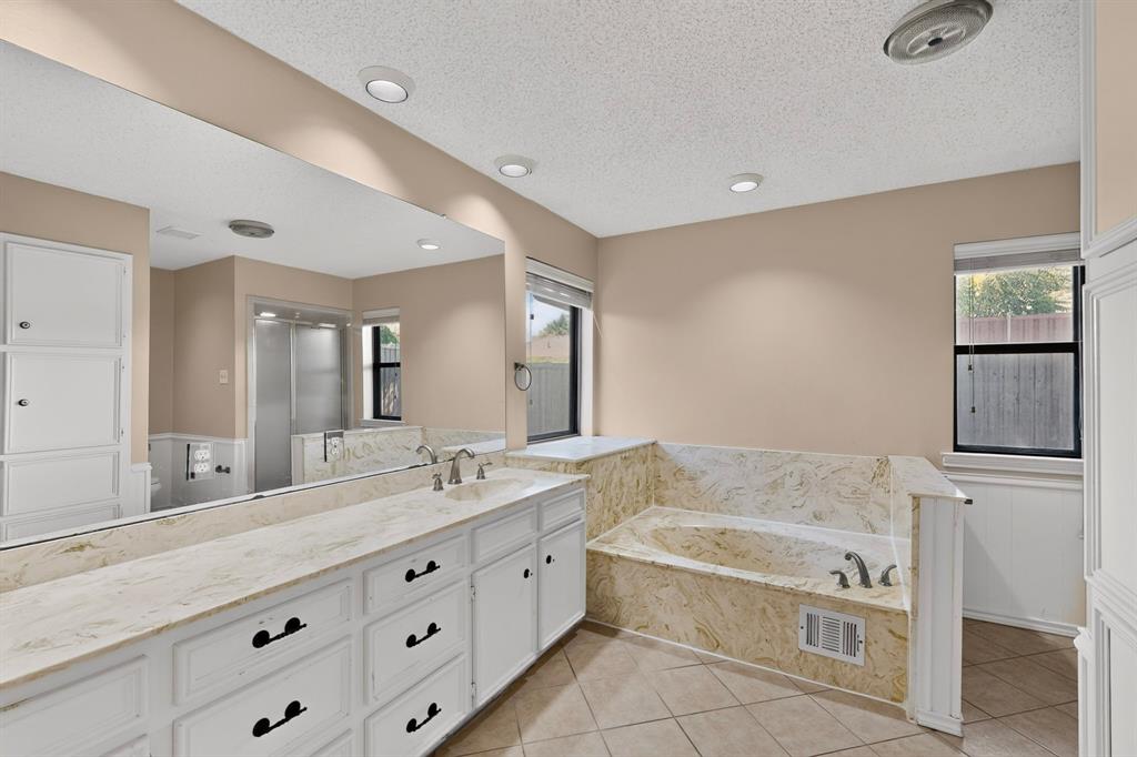 Expansive vanity with dual undermount sinks, stone-finish countertop, and full-wall mirror