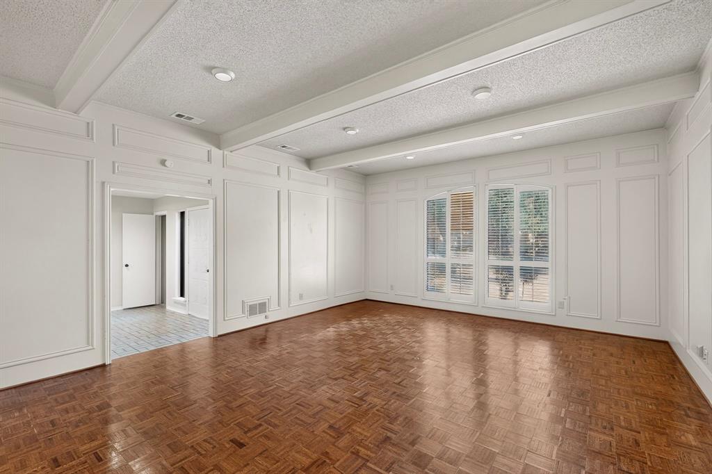 Wall paneling with decorative trim, wood-finish flooring, coffered ceiling, recessed lighting, and large windows