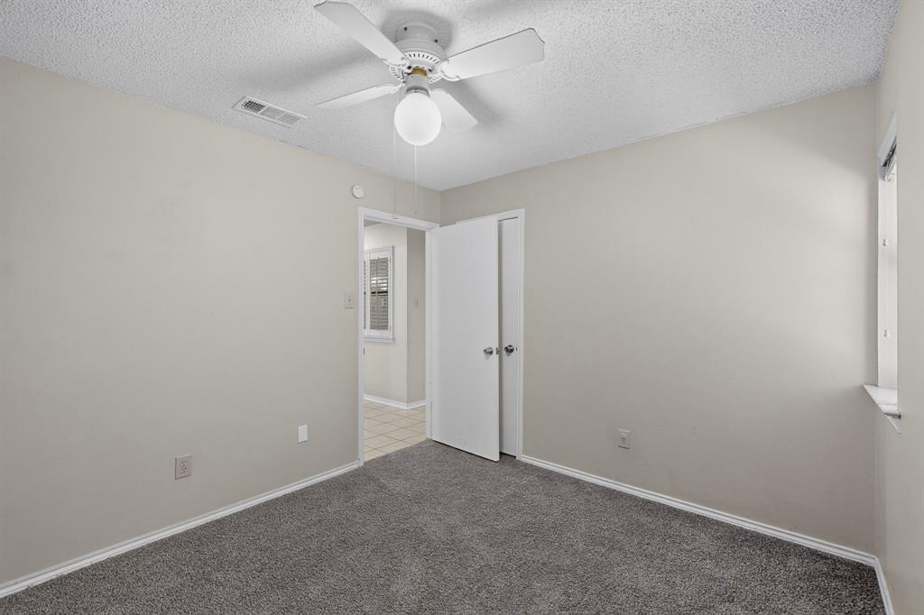 Wall-to-wall carpeting, ceiling fan, and window