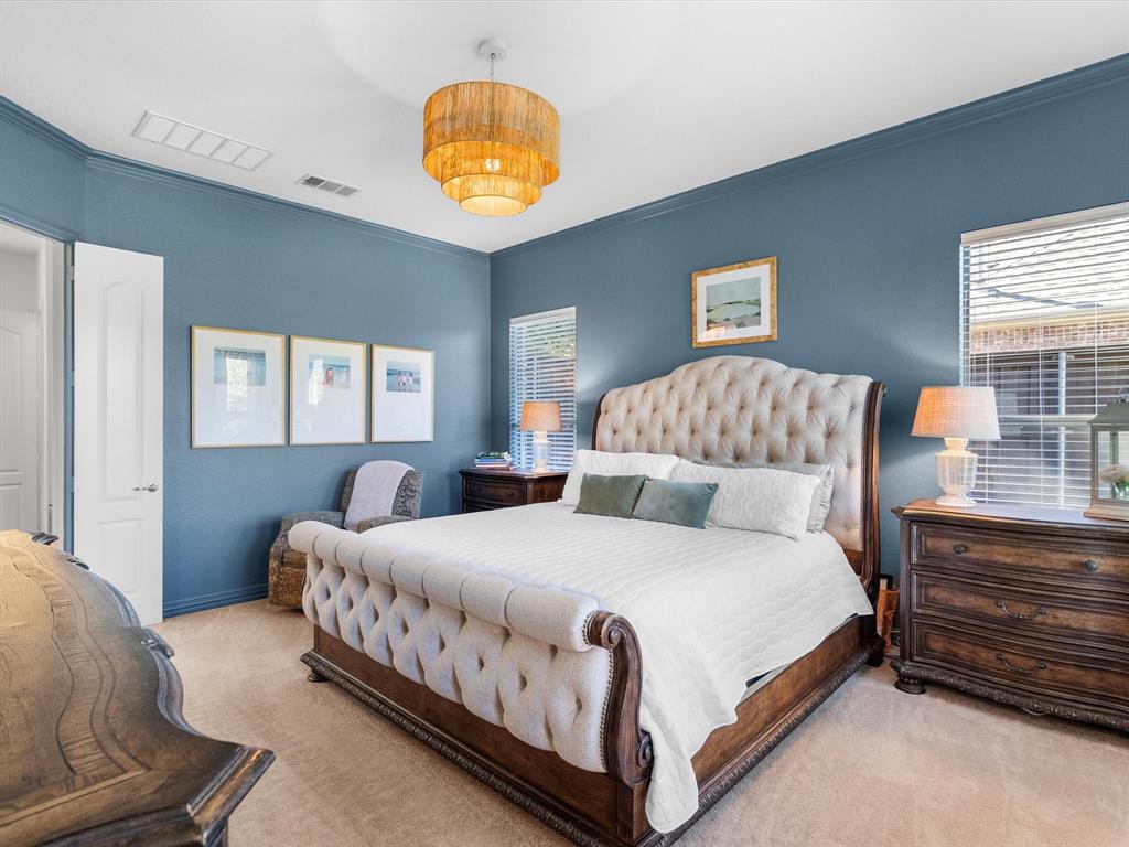Private, first-level primary bedroom is spacious and off of the main living space with updated lighting and views of the backyard