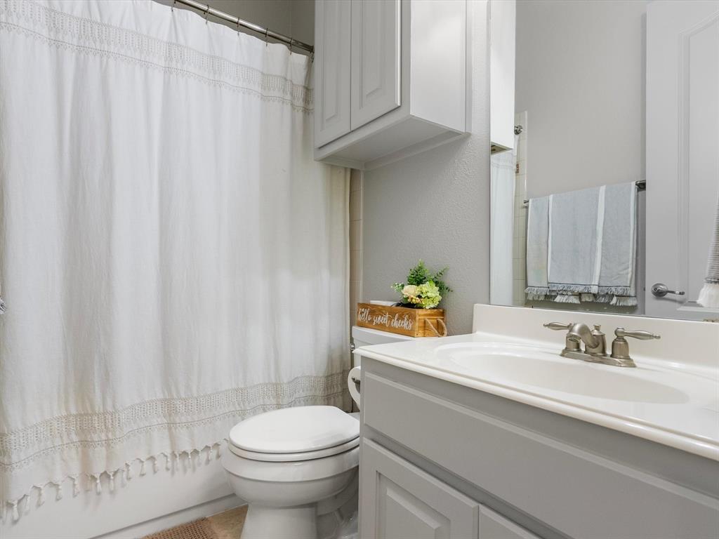 First-level full bathroom with shower/tub combo and storage cabinets