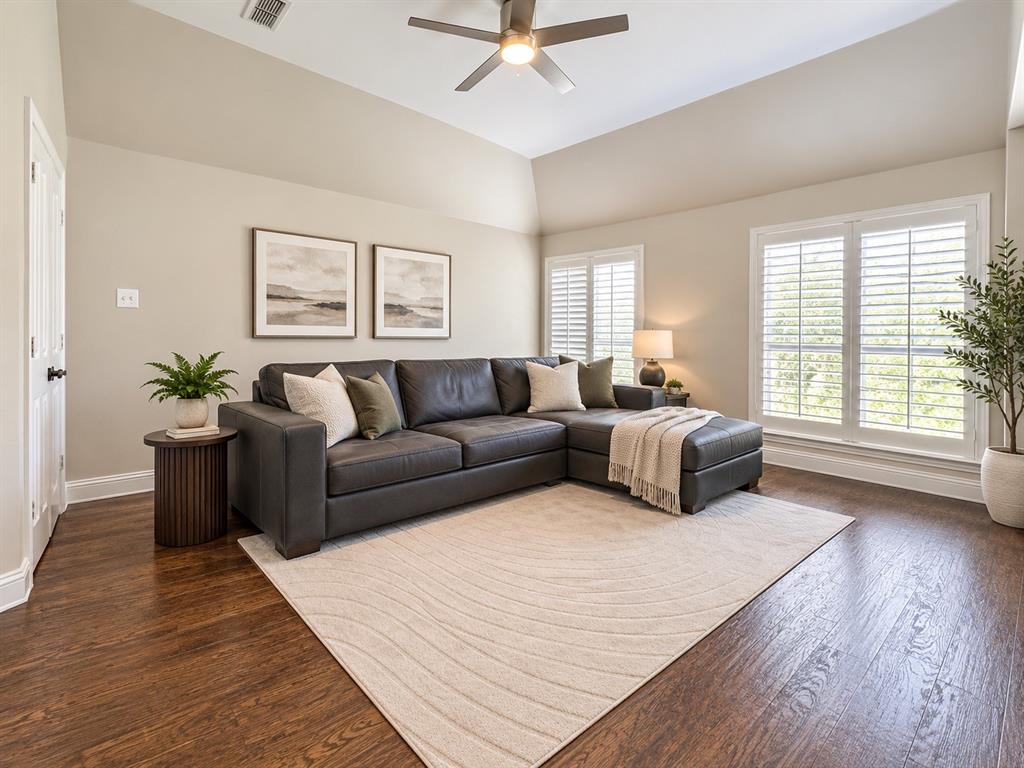 Wood-finish flooring throughout, complemented by a vaulted ceiling with a ceiling fan