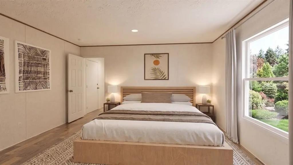 Bedroom featuring wood-finish flooring, recessed lighting, and a large window with exterior greenery