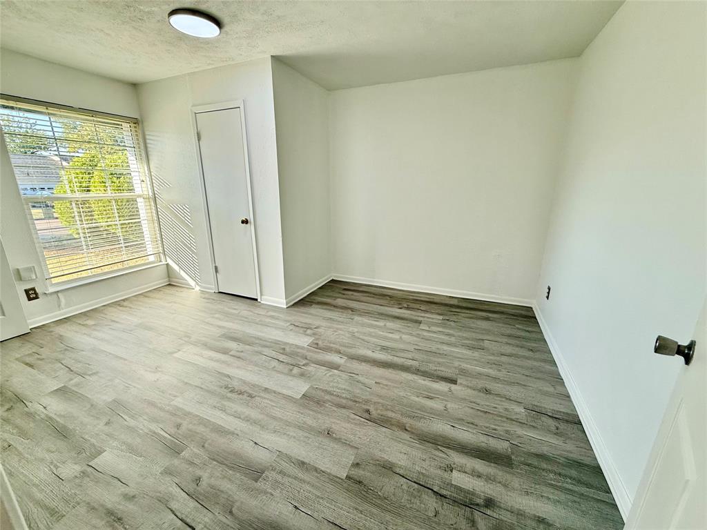 Wood-finish flooring, white walls, and a ceiling-mounted light fixture Wood-finish flooring, white walls, and a ceiling-mounted light fixture