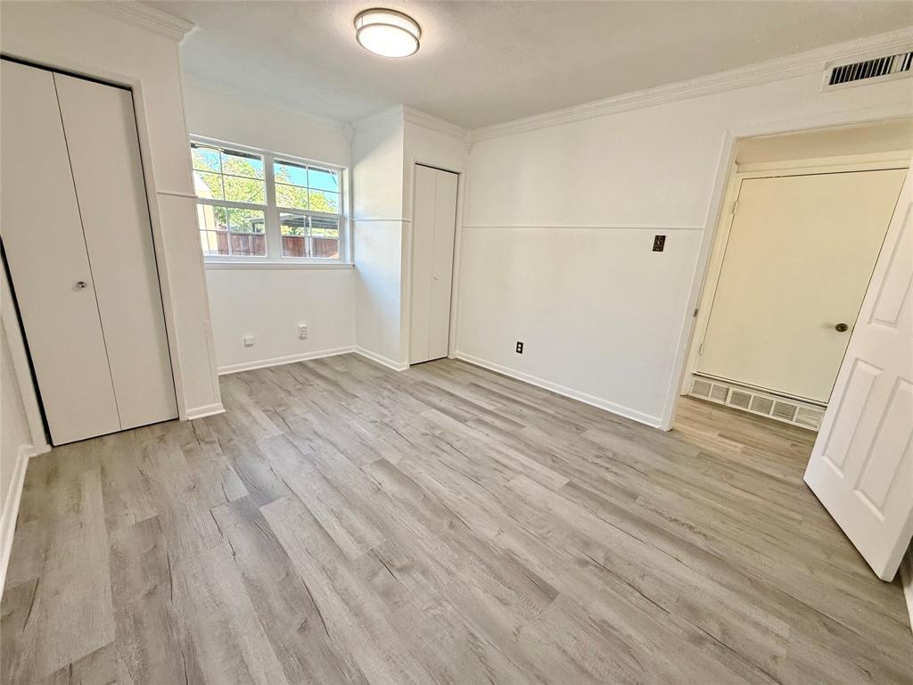 Wood-finish flooring, crown molding, and two bi-fold door closets