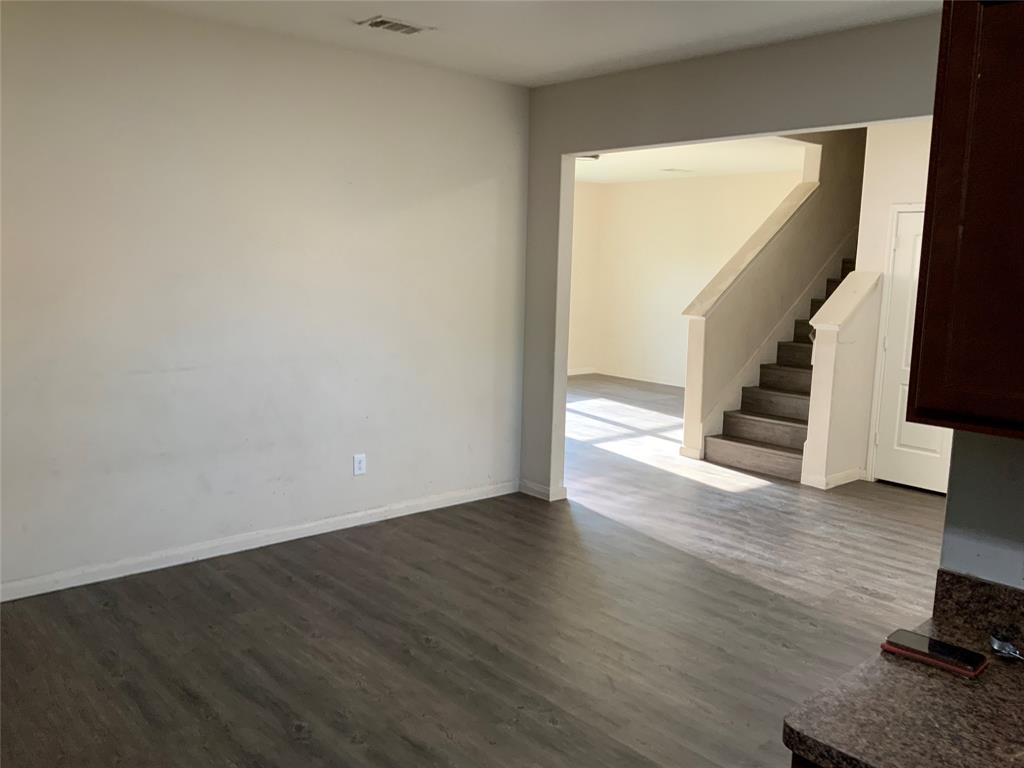 Wood-finish flooring throughout, light-toned wall paint, and a built-in staircase with neutral-toned risers Wood-finish flooring throughout, light-toned wall paint, and a built-in staircase with neutral-toned risers