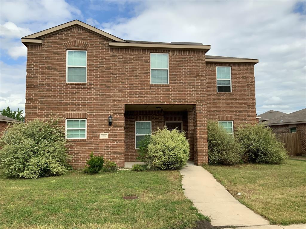 Brick exterior construction with multiple windows, covered entry, and a concrete pathway