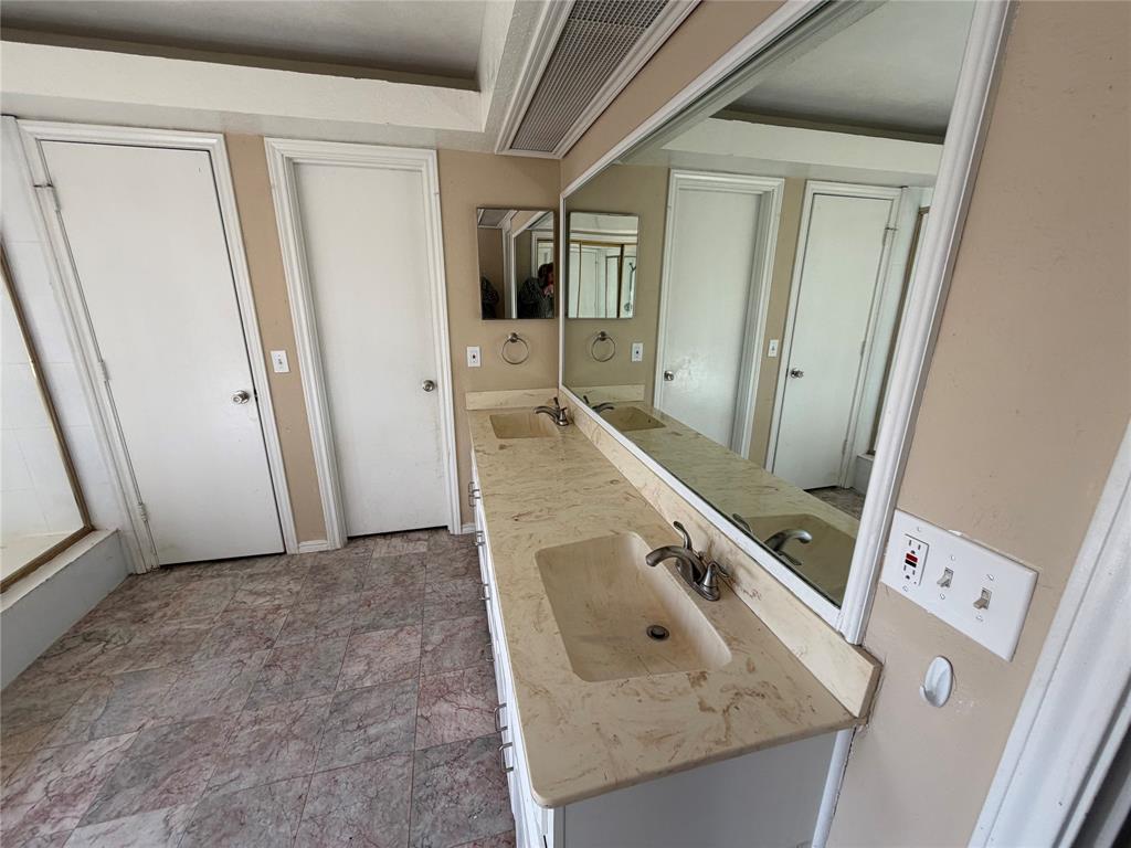 Dual vanity with integrated sinks, expansive mirror, and patterned floor tile