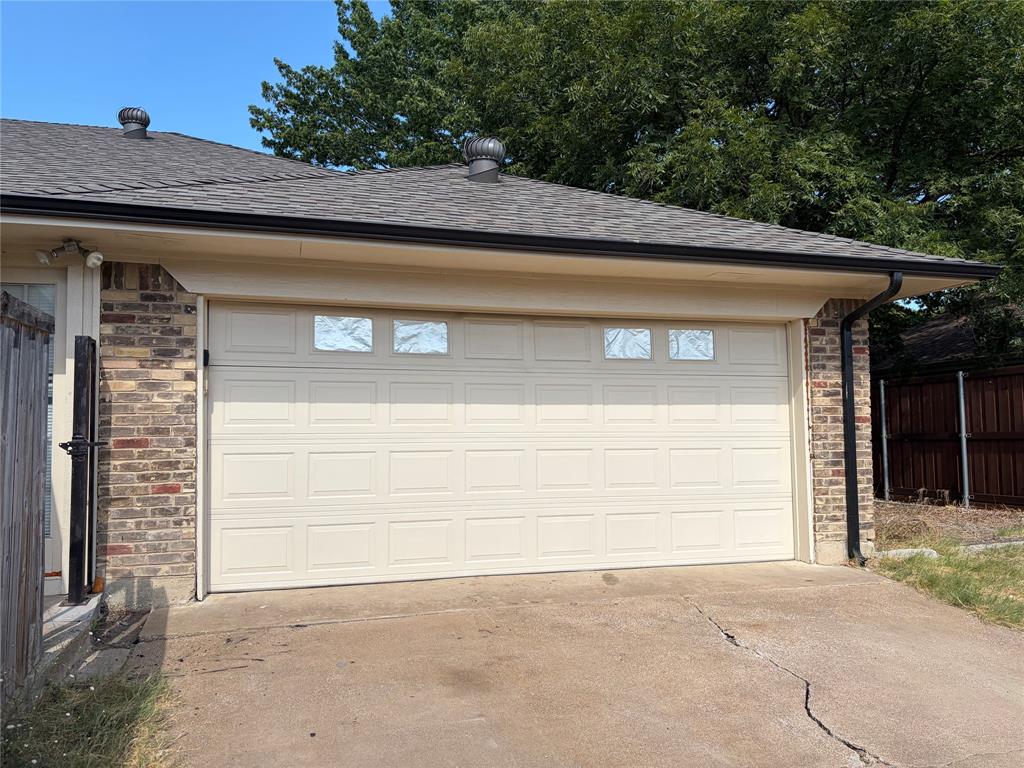 Brick veneer exterior with an attached garage featuring paneled doors