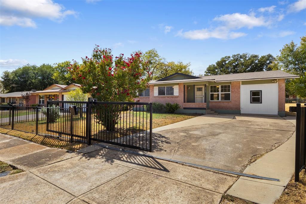 Brick exterior with a partial white facade, a multi-pane window, and a concrete driveway
