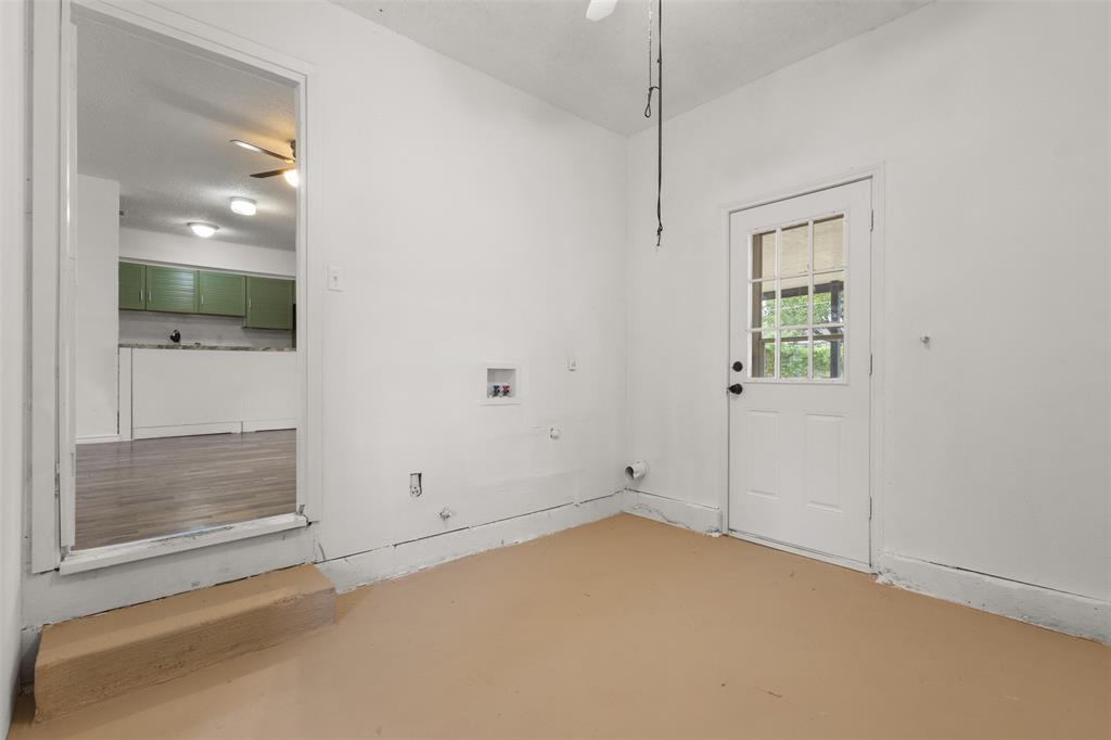 Utility room featuring a paneled door with glass inserts, dedicated laundry hookups, and a neutral-toned floor